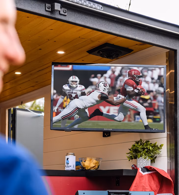 Mounted smart TV and built-in sound system inside an Ice House trailer